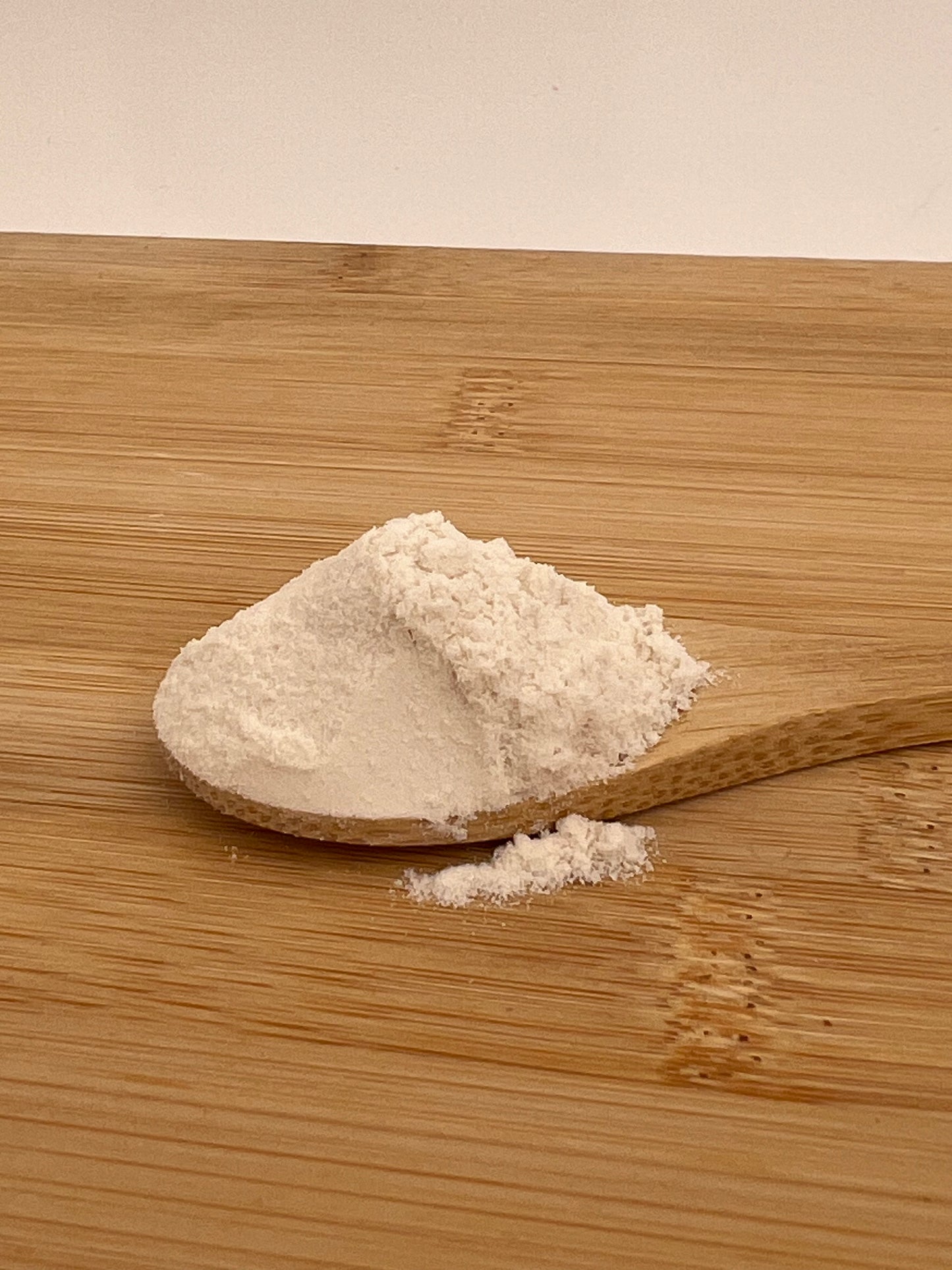 Close up of fine tremella mushroom powder on a wodden spoon. Best UK price for 100% pure tremella powder, excellent quality, best prices in the UK. No pesticides used in these pure products